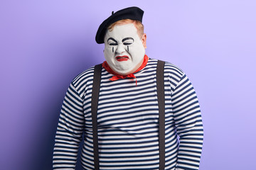 Obraz premium crying mime wearing striped sweater, beret. close up photo. negative feeling and emotion. facial expression