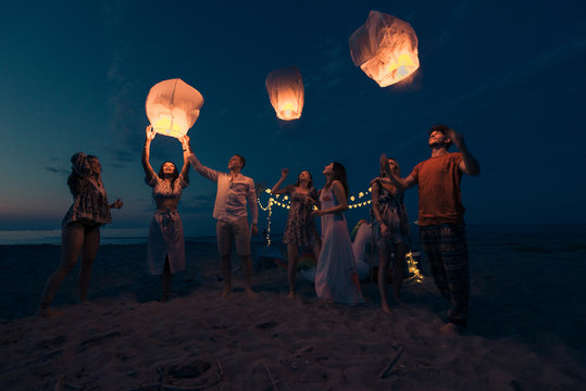 Group of friends lighting lanterns