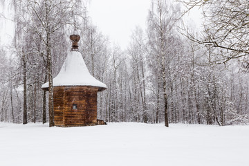 Orthodox wooden old multi domed church or chapel, monuments of winter architecture during a snowfall in Russia