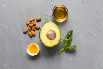 Keto food: avocado, eggs, oil, nuts, spinach. Flat lay. Healthy food concept