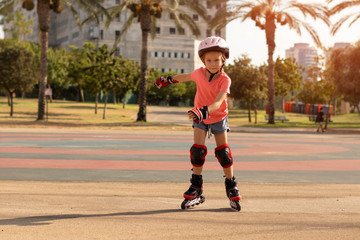 Child on inline skates in park. Kids learn to skate roller blades