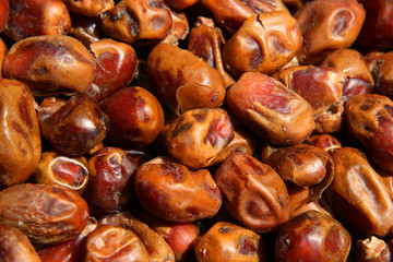 Date fruit closeup background. Heap of dried shiny brown red date fruit. Top view.