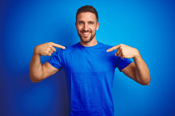 Young handsome man wearing casual t-shirt over blue isolated background looking confident with...
