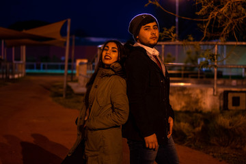 Pareja posando mirando a cámara en la noche