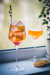 Aperol spritz cocktail with ice in glass on on the windowsill