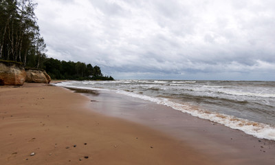 Storming sea with a thundercloud above,  beautiful rugged coastline with waves crashing against the cliffs, Veczemju cliffs, Latvia