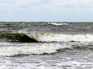 beautiful waves going to the coast, stormy sea with thunder clouds over,