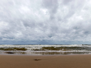 beautiful waves going to the coast, stormy sea with thunder clouds over,
