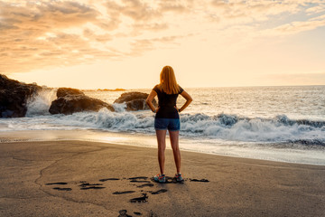 Romatic girl standing on sunset beach Tenerife