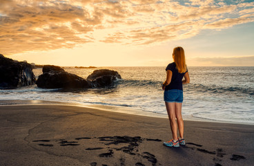 Romatic girl standing on sunset beach Tenerife