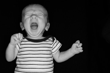 A 3 Week Old Baby Poses on a Black Background. Perfect for Memes with Copy Space.