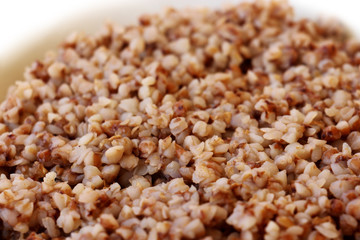 fresh cooked tasty healthy cereal buckwheat porridge on a white plate for breakfast