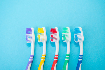 set of plastic toothbrushes on blue background