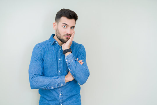 Young handsome man over isolated background thinking looking tired and bored with depression problems with crossed arms.