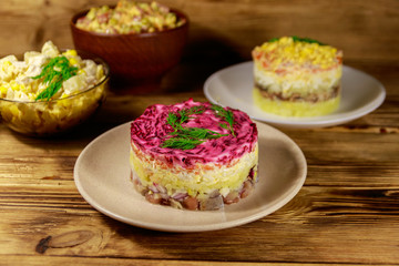 Set of festive mayonnaise salads on wooden table