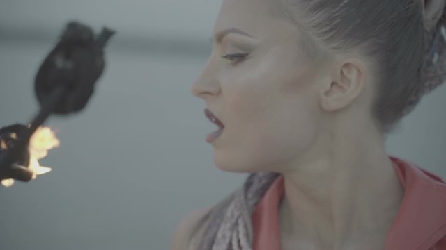 Girl blows out a torch with fire. slow motion S-Log3, S-Gamut3, Cine