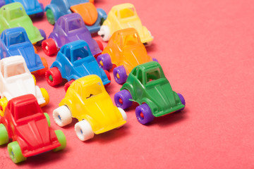 Obraz premium Toys plastic cars on a red background