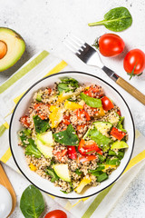 Quinoa salad with fresh vegetables on white.