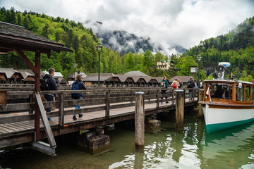 Fototapeta na wymiar Scenic view on Konigssee Lake with wooden pier with moored touristic ship