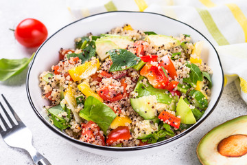 Quinoa salad with fresh vegetables on white.