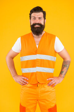 Safety Equipment Concept. Safety Apparel For Construction Industry. Bearded Brutal Hipster Safety Engineer. High Visibility Reflective Safety Vest. Man Worker Protective Uniform Orange Background