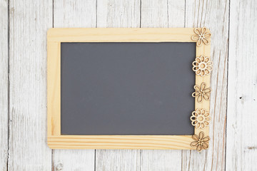 Blank chalkboard with flowers on weathered whitewash textured wood background