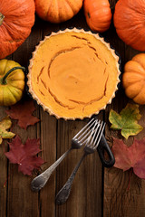 Homemade sweet pumpkin pie in cast iron pan with vintage forks on wooden background rustic style top view