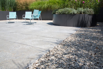 Moderne Garten- und Terrassengestaltung im Materialmix: Terrasse aus Steinplatten umgeben von...