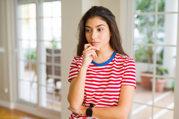 Young beautiful woman thinking and wondering with a hand on chin, doubt concept