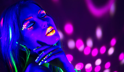 Fashion disco woman. Dancing model in neon light, portrait of beauty girl with fluorescent makeup....