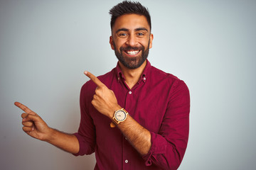 Young indian man wearing red elegant shirt standing over isolated grey background smiling and...