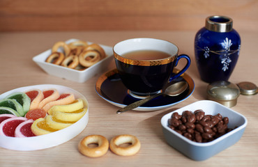Cup of tea, fruit jelly, chocolate covered raisins, ring-shaped cracknel