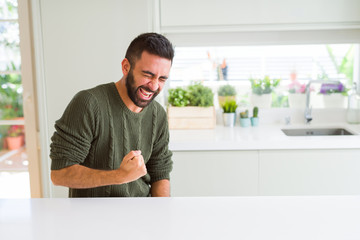 Handsome man celebrating and cheering with excitement expression, smilling for winning success