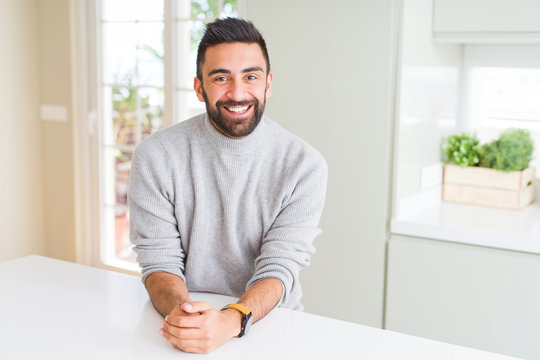 Handsome hispanic man wearing casual sweater at home with a happy and cool smile on face. Lucky person.