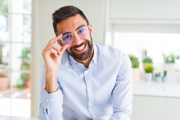 Handsome business man wearing glasses and smiling cheerful with confident smile on face