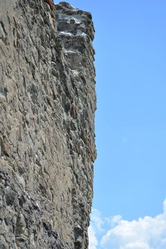 Old stone wall of the ancient Georgian fortress Ujarma against the blue sky