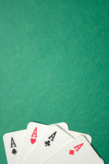 Four aces on a green background. Top view. Copy space. Vertical.