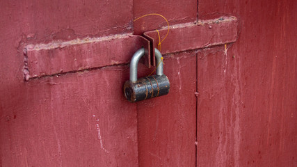 Old rusty lock red gates peeling paint day light bright