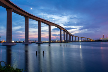 The Jordan Bridge over the Elizabeth River on the border of Norfolk and Chesapeake Virginia against a beautiful red, purple, pink, and blue sunset