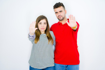 Young beautiful couple hugging together over white isolated background with open hand doing stop sign with serious and confident expression, defense gesture