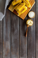 Fried corn on board with salt and butter on wooden background top view mockup