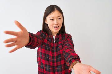 Young chinese woman wearing casual jacket standing over isolated white background looking at the camera smiling with open arms for hug. Cheerful expression embracing happiness.