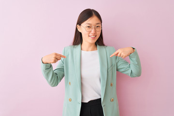 Young chinese businesswoman wearing jacket and glasses over isolated pink background looking...
