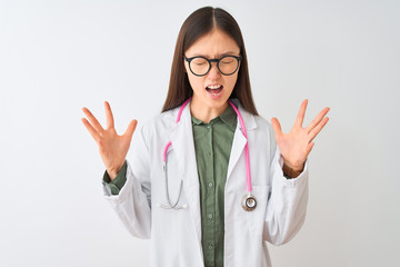 Young chinese dooctor woman wearing glasses stethoscope over isolated white background celebrating mad and crazy for success with arms raised and closed eyes screaming excited. Winner concept