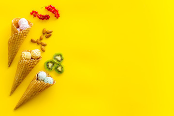 summer dessert with ice cream in cones on yellow backgroung top view mockup
