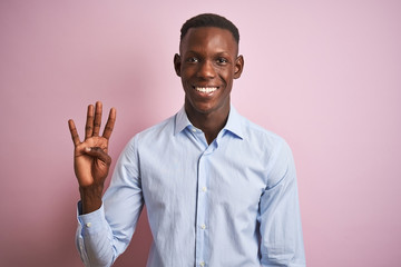 African american man wearing blue elegant shirt standing over isolated pink background showing and pointing up with fingers number four while smiling confident and happy.