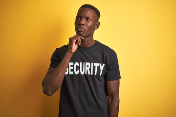 African american safeguard man wearing security uniform over isolated yellow background with hand...