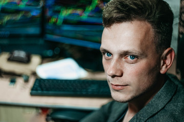 Young male businessman at a computer monitors the schedule of exchange rates on the online cryptocurrency exchange