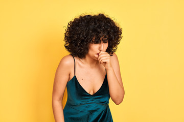 Fototapeta na wymiar Young arab woman with curly hair wearing elegant dress over isolated yellow background feeling unwell and coughing as symptom for cold or bronchitis. Healthcare concept.