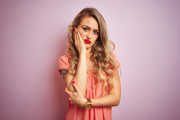 Young beautiful woman wearing t-shirt standing over pink isolated background thinking looking tired and bored with depression problems with crossed arms.
